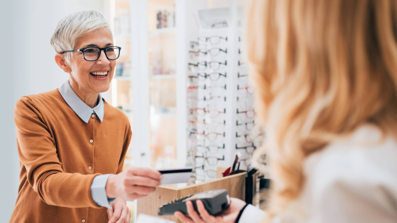 Woman scanning her credit card in optometry office