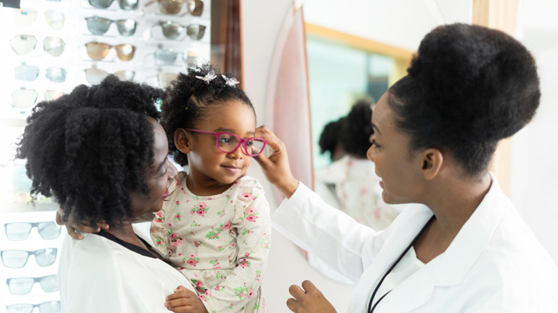 Provider helping child with new glasses