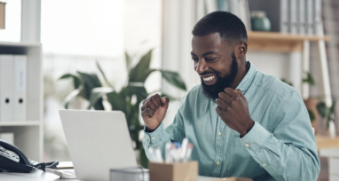 Person smiling at laptop - How to Save Time and Money with Automation 